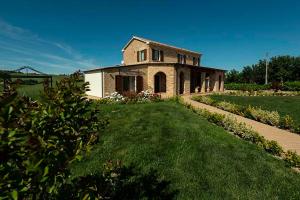 an old stone house on a field with a grass yard at B&B Olmo in Saludecio