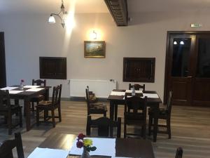 una sala da pranzo con tavoli e sedie in legno di Pensiunea Valea Pinului a Rau Sadului
