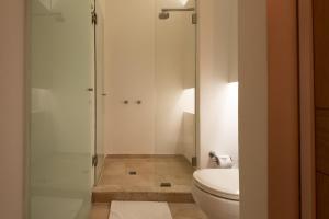 a bathroom with a toilet and a glass shower at Delirio Hotel in Cartagena de Indias