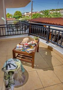 a table on top of a balcony with a view of a roof at Konstantina & Evgenia Deluxe Apartment in Nea Peramos