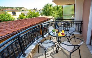 a balcony with chairs and a table with fruit on it at Konstantina & Evgenia Deluxe Apartment in Nea Peramos
