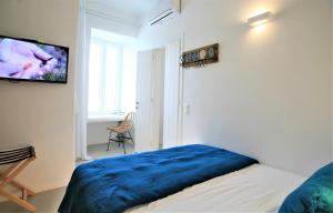 1 dormitorio con 1 cama y TV en la pared en Lasia Boutique Apartment, en Ándros