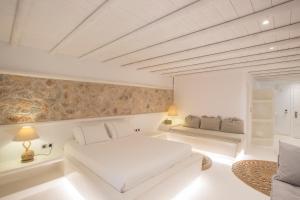a white room with a bed and a couch at Paros Palace in Parikia