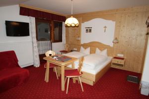 1 dormitorio con 1 cama, 1 mesa, 1 cama y 1 silla en Alpenbauernhof Gröbenhof, en Fulpmes