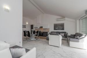 sala de estar con sofá, sillas y mesa en Beautiful penthouse for 8 close to city center, en Novalja