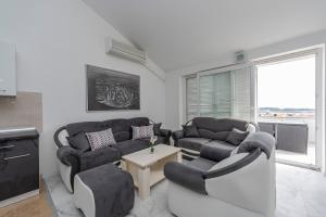 a living room with two couches and a table at Beautiful penthouse for 8 close to city center in Novalja