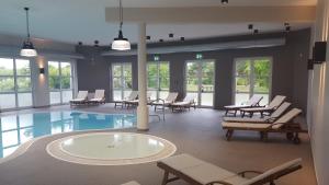 una grande stanza con piscina, sedie e tavoli di Ferienidyll Nordwind a Dranske