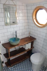 a bathroom with a sink and a toilet and a mirror at Cambridge Boat Hire in Chesterton