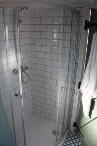 a shower with a glass door in a bathroom at Cambridge Boat Hire in Chesterton
