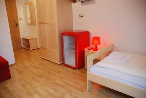 a room with a red refrigerator and a bed at In Vino Bed & Breakfast in Pohořelice