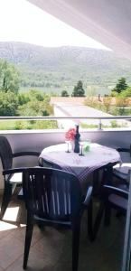 a table with a vase on it on a patio at Apartments Nevistic in Tribalj