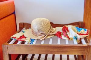 a hat sitting on top of a crib with towels at Konstantina & Evgenia Deluxe Apartment in Nea Peramos