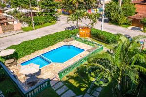 
a pool with a pool table and a lawn chair at Pousada Vivamar in Ubatuba
