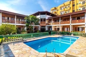 a swimming pool in front of a building at Pousada Vivamar in Ubatuba