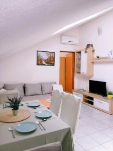 una sala de estar con una mesa y un sofá en Apartments Nevistic, en Tribalj