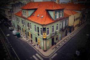 a large building with an orange roof on a street at Hostel Matosinhos Suites in Matosinhos