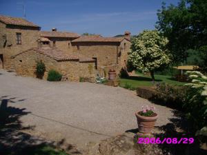 una casa de piedra con una entrada delante de ella en Villa Fonte all'Oppio con area piscina recintata, en Pienza