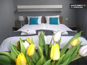 een slaapkamer met een bed met gele en witte bloemen bij Kamienica Grand Starówka in Elblag