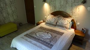 a bedroom with a bed with a white bedspread and pillows at Chambres de Monthéard in La Bazoge