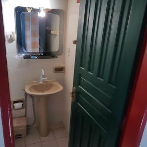 a bathroom with a green door and a sink at Pousada Bela Paraty in Paraty