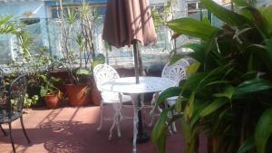 a table with two chairs and an umbrella on a patio at Casa Colonial Yadilis y Yoel in Havana