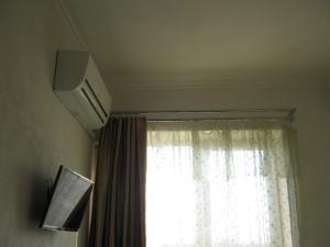 a window with a white curtain and a television at Мини отель П88/1 in Odesa