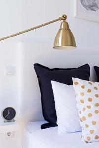 a lamp sitting on top of a bed with pillows at Bom Porto Apartments in Porto
