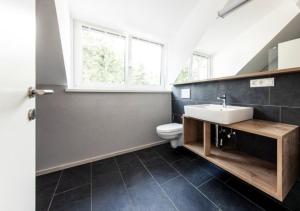 een badkamer met een wastafel, een toilet en een raam bij Residence Belmonte in Collalbo