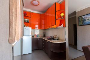 a kitchen with orange cabinets and a white refrigerator at Apartament on Rustaveli in Batumi