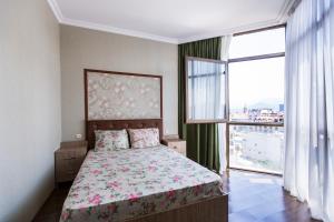 a bedroom with a bed and a large window at Apartament on Rustaveli in Batumi
