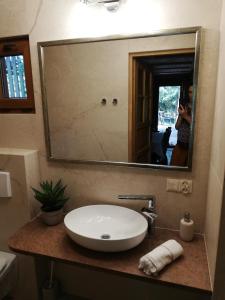 a bathroom sink with a mirror and a person taking a picture at Domek Moczykija in Szypliszki