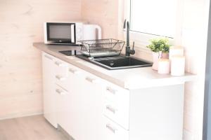 a kitchen with a counter top with a microwave at Nadmorska Przystan - Domki caloroczne in Ustka