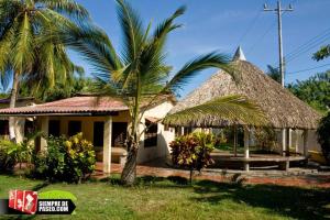 una casa con techo de paja y una palmera en Cabaña Coveñas Punta Bolivar, en Coveñas
