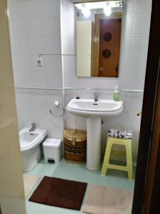 a bathroom with a sink and a toilet and a mirror at Amplio Loft con plaza de garaje in Cangas de Onís