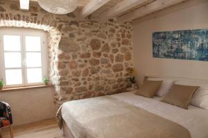 a bedroom with a bed and a stone wall at Sobe Bile in Pag