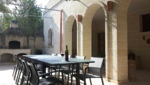 una mesa con sillas y una botella de vino en el patio en Tenuta Tufo nel Blu, en Maruggio