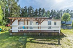 a tiny house with a deck in a yard at Domki Lena Kopalino in Kopalino