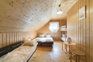 a room with two beds in a wooden cabin at Domki Lena Kopalino in Kopalino