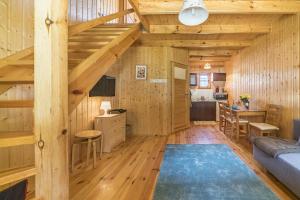 a living room with wooden walls and wooden flooring at Domki Lena Kopalino in Kopalino