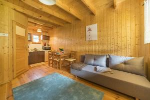 a living room with a couch and a kitchen at Domki Lena Kopalino in Kopalino