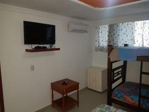 Pokój z telewizorem na ścianie i łóżkiem piętrowym w obiekcie Apto en Rodadero Palanoa 605 Dos Habitaciones 7 personas w mieście Santa Marta