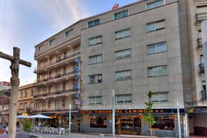 un edificio con una cruz delante de él en Hotel Virgen del Camino Pontevedra en Pontevedra