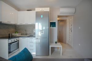 a kitchen with a stainless steel refrigerator and a table at Akti Alegra Apartment in Neos Marmaras