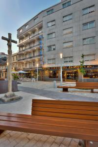 a bench in front of a building with a cross at Hotel Virgen del Camino Pontevedra in Pontevedra