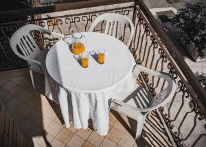 ペスキエーラ・デル・ガルダにあるLa Forgia Apartmentの白いテーブル(椅子2脚付)とオレンジジュース2杯