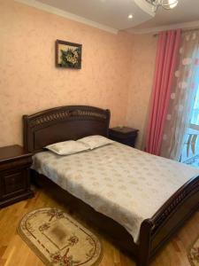 een slaapkamer met een bed, 2 tafels en een raam bij Хорошая Квартира в Центре 1 in Baku