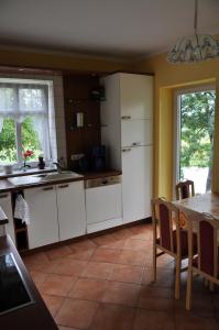 una cocina con armarios blancos y una mesa con mesa en Hof Richert en Mellen