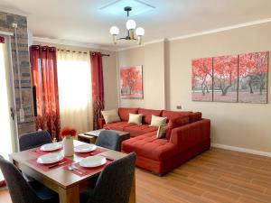 een woonkamer met een rode bank en een tafel bij EKA Luxury Apartments in Durrës