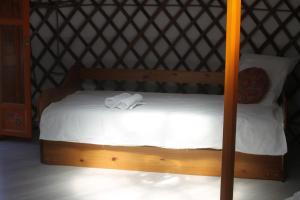una cama de madera con 2 toallas encima en Yourte Grain de Folie, en Waben
