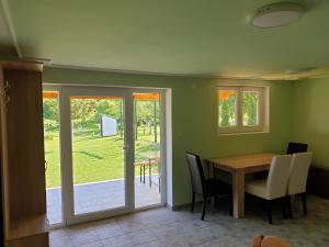 a dining room with a table and chairs and a sliding glass door at Kula House Vrdnik in Vrdnik